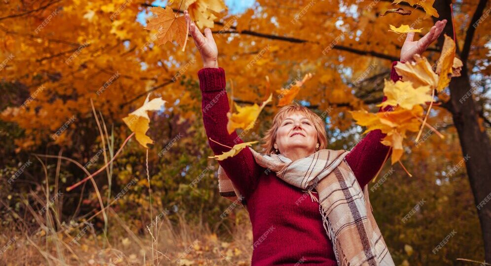 middle-aged-woman-throwing-leaves-forest-happy-senior-lady_106029-356